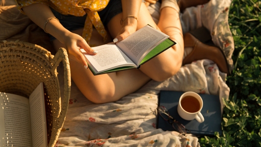 Mujer sentada leyendo con una taza de té endulzada con muna monk fruit blend